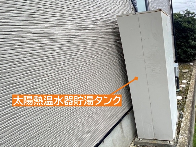外壁沿いに設置された太陽熱温水器の貯湯タンク