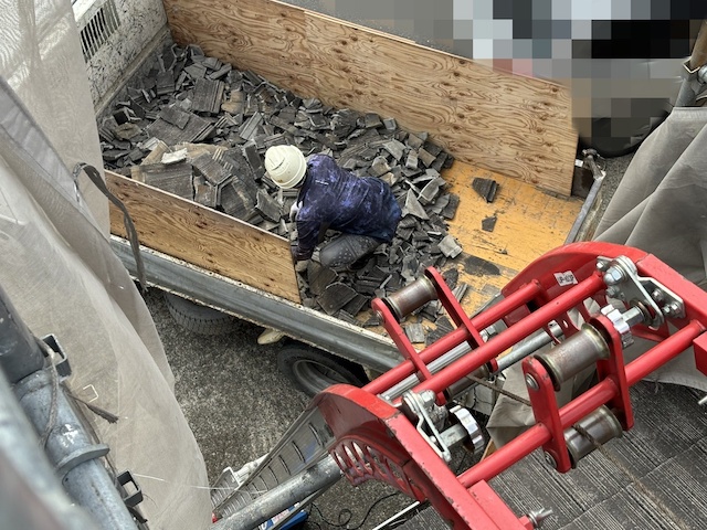 撤去した瓦をダンプに積む