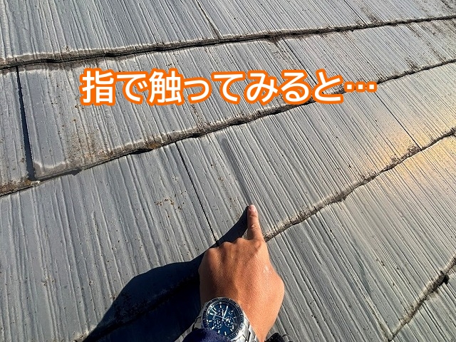 スレート屋根の表面を指で触れて確認