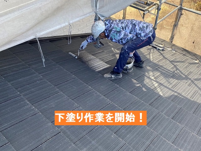 スレート瓦へ下塗りを行う職人