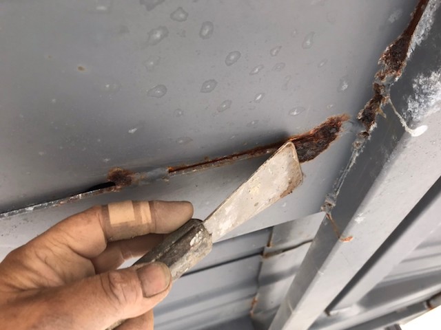 スクレーパーを使用して錆を落としにかかる職人