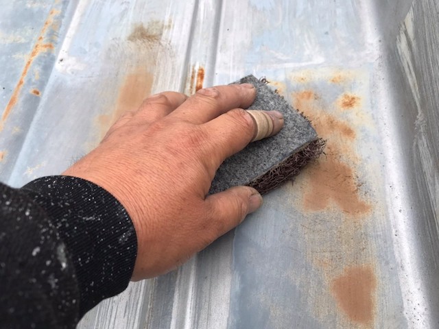 マジックロンを使用して錆を削る職人