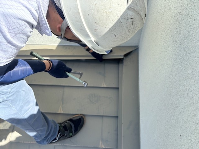 壁際板金を外す職人