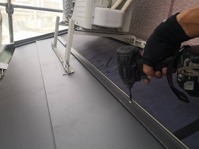 下屋根に金属材でカバー工事を実施する職人