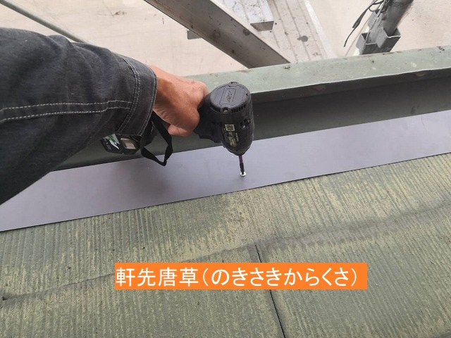 下屋根の軒先に唐草板金を施工する職人