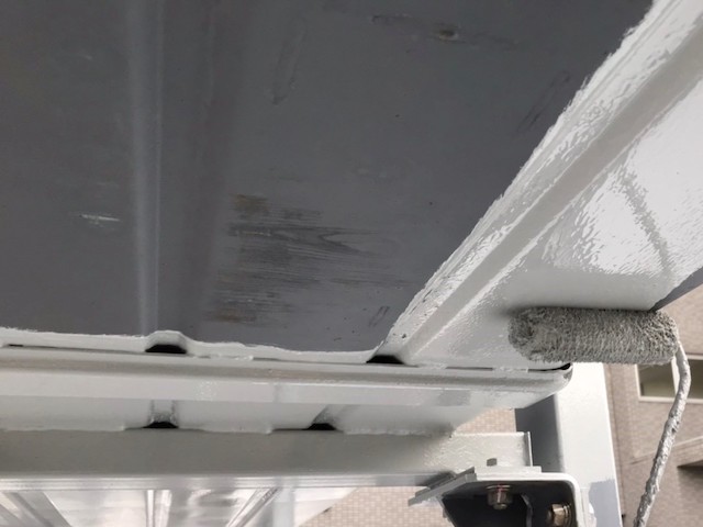機械式駐車場の裏面に錆び止め塗料を塗布する職人