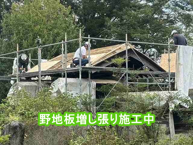 門の屋根に野地板を増し張りする大工職人