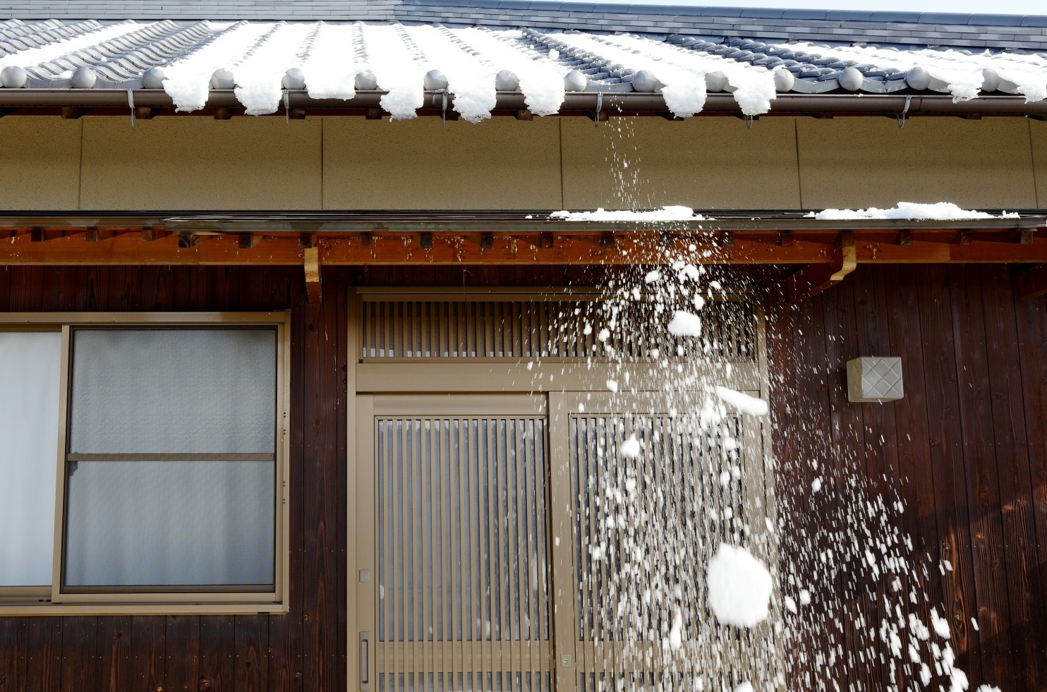 瓦屋根から雪が落ちる様子