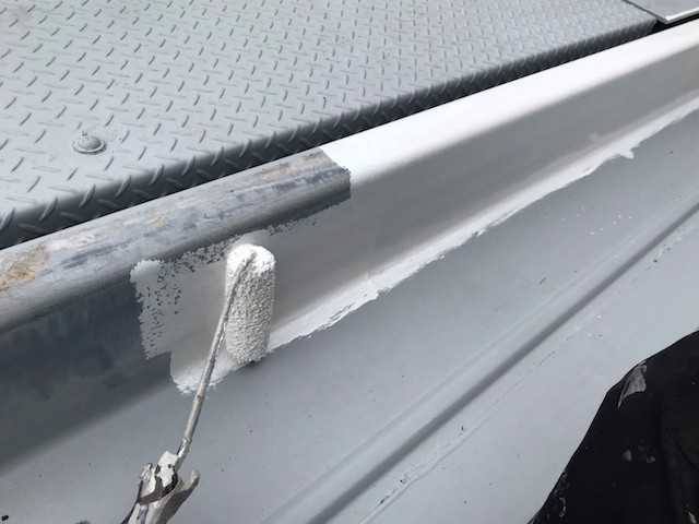 二段式駐車場に立上り部分に下塗りを行う職人