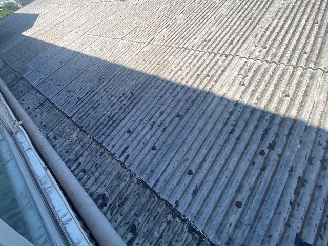 灰色の石綿スレート屋根と外壁緩衝部