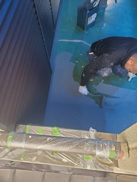 ウレタン防水の本材をローラーで塗布する職人