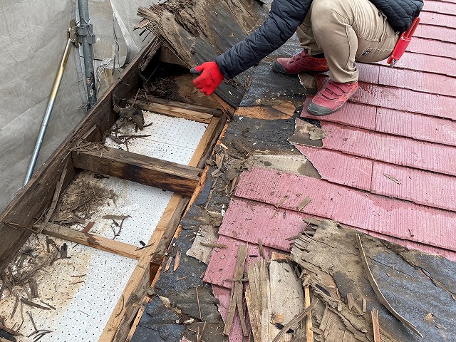 漏水して腐食した野地板を撤去する職人
