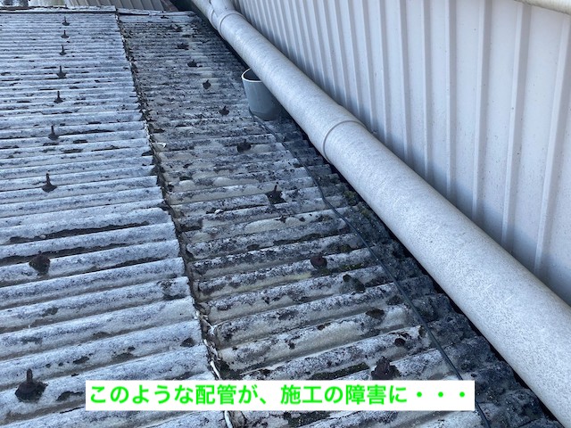 小波スレートの軒先上に通るパイプ