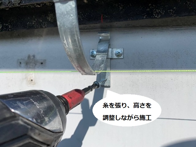糸を張って高さを調整しながら雨樋用の支持金具を施工