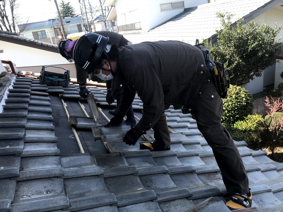 葺き直しの下地工事が終わり既存の瓦を葺き直す職人