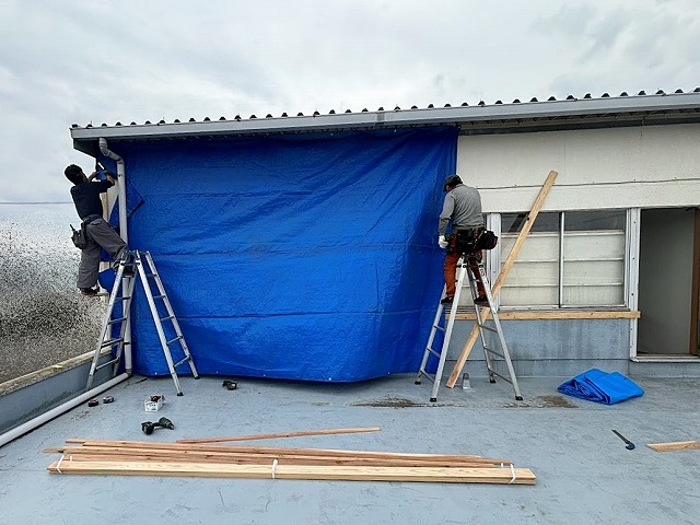 塔屋の一面をブルーシートで養生中