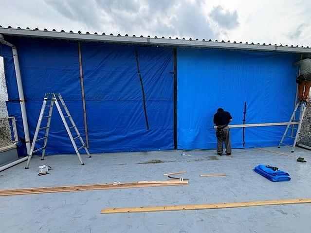 雨水漏れを起こした塔屋の外壁一面を養生中