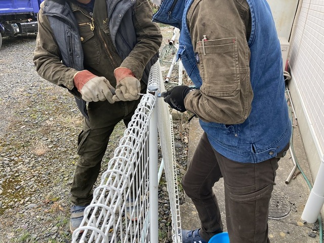 工具で外溝フェンスの解体を行う二名の職人