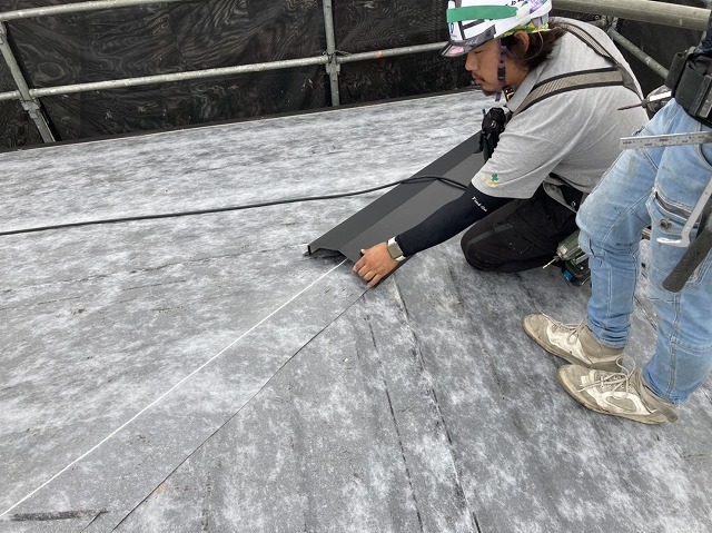 棟板金の位置を確認する職人