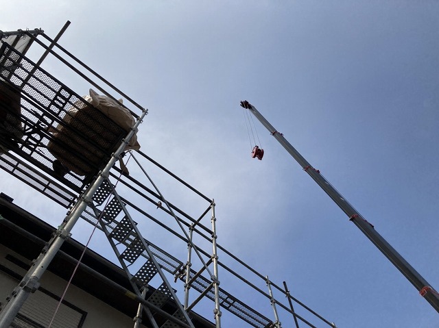 ユニックでの荷降ろしを地上から見上げる