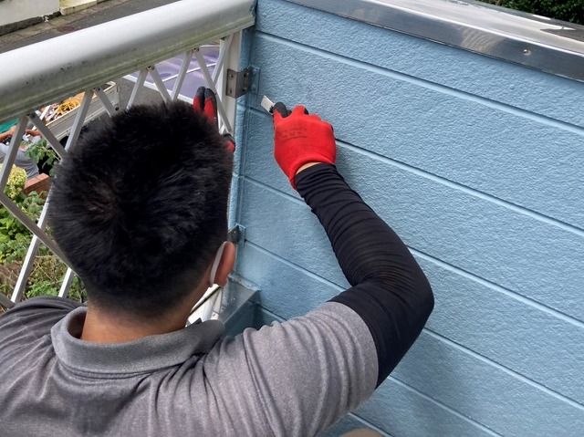 ベランダの腰壁の撤去を始めた職人