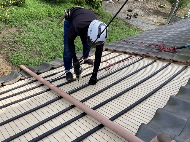 屋根の雨漏り修理を行う職人