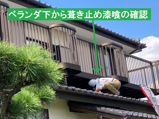 下屋根からベランダ下を覗き込むスタッフ