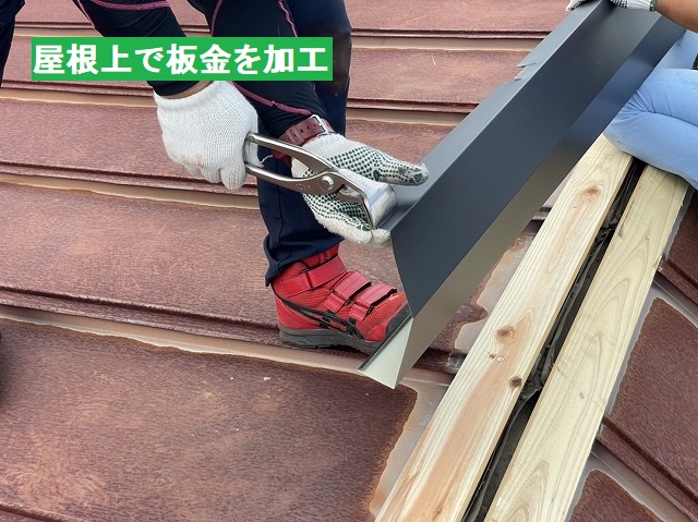 屋根上で棟板金を加工する職人