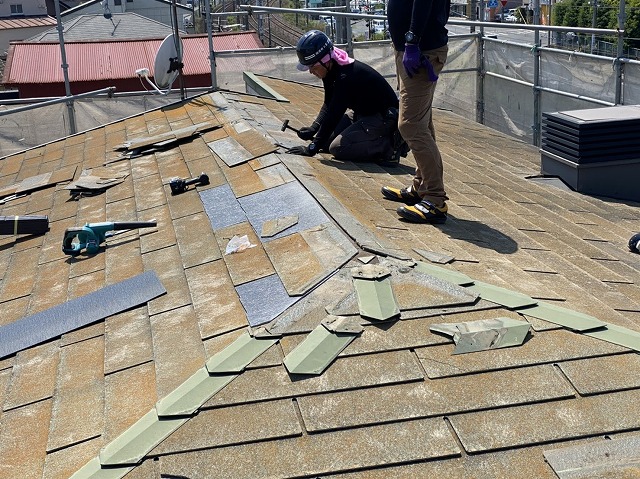 スレート屋根を部分的に差し替え修理を行う職人