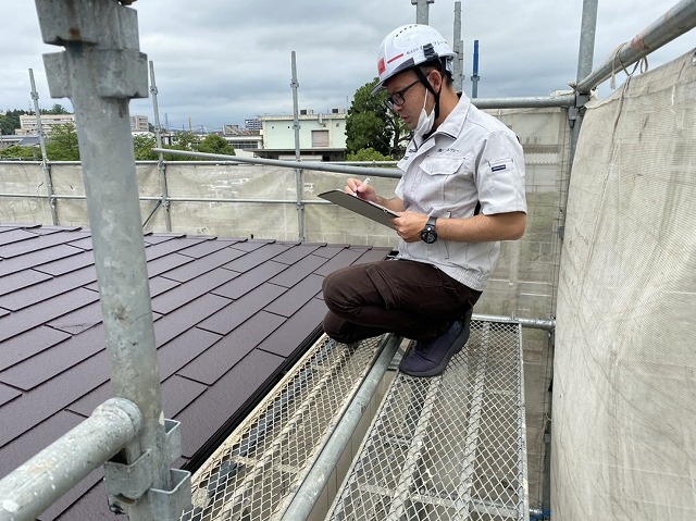 屋根修理状態をチェツクするスタッフ