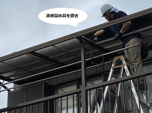 脚立に登り波板の留め具をインパクトで撤去する職人