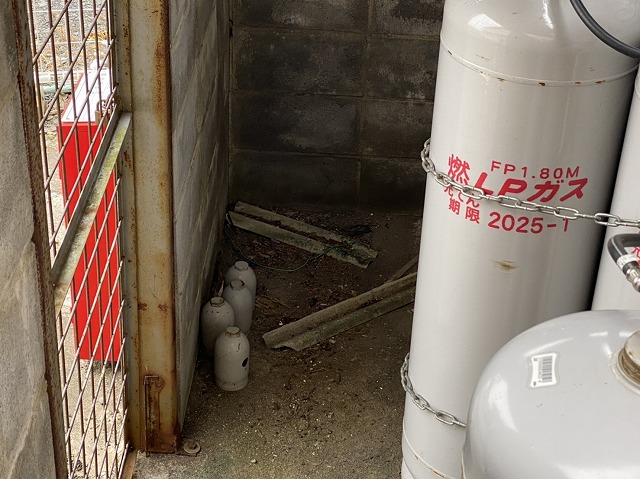 プロパンガスが設置されたボンベ庫に落ちている大波スレートの破片