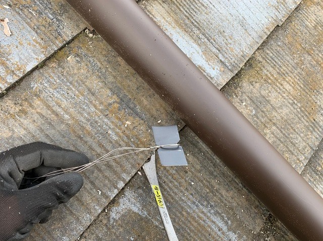 加工した板金に番線をつけて這い樋の押さえ材にする