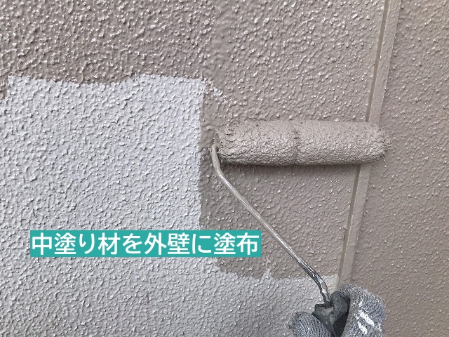 中塗り材をモルタル外壁に塗布中