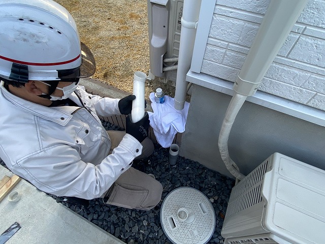 雨樋のクランク部を交換補修するスタッフ