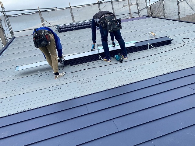 二名の職人が屋根工事を行う様子