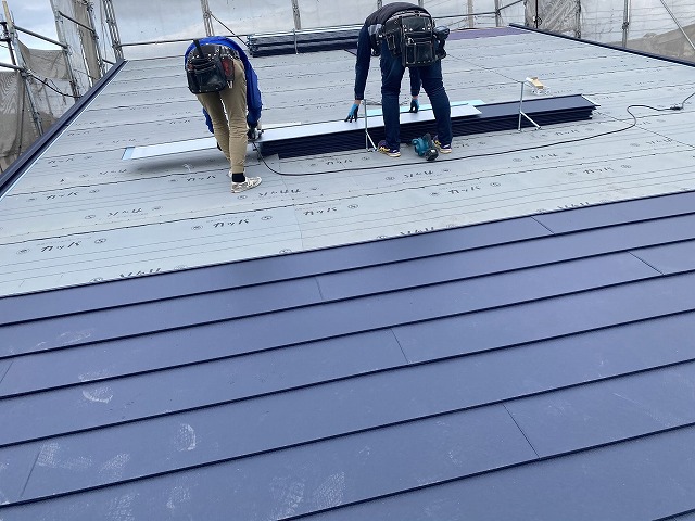 二名の職人が連携して屋根工事を実施