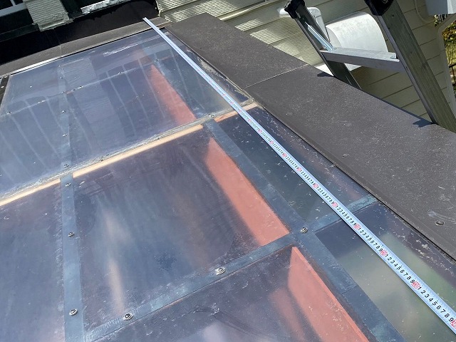 平板パネルの寸法をスケールで計っている