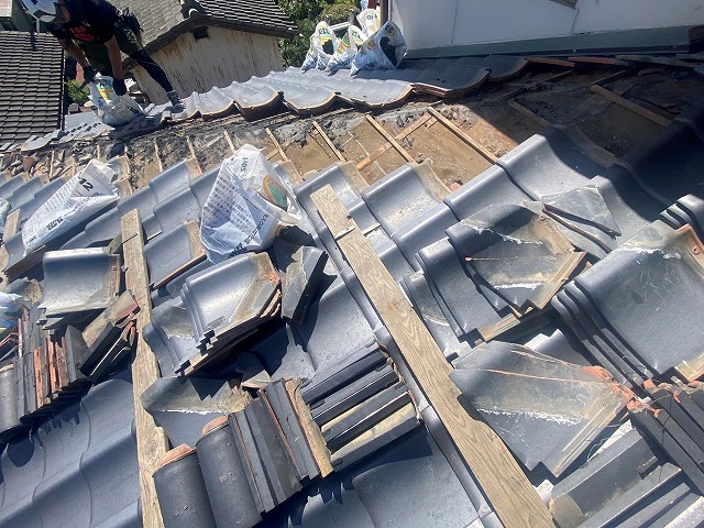 隅棟から出た残土を袋詰めする職人