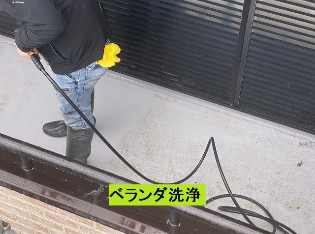ベランダに高圧洗浄をかけるスタッフ