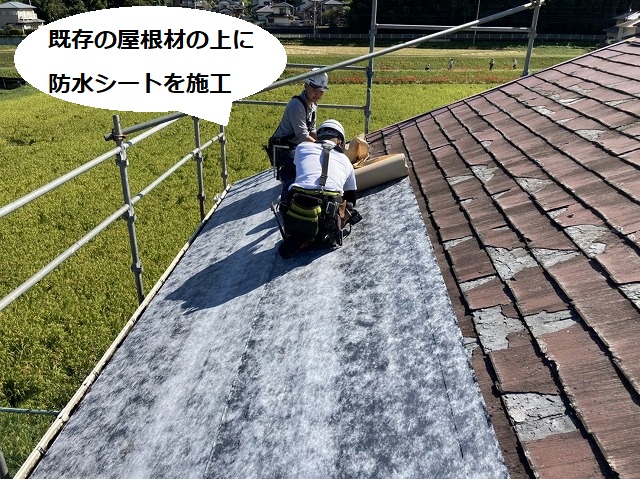 破損の激しいスレート屋根パミールに粘着式防水シートを張る職人