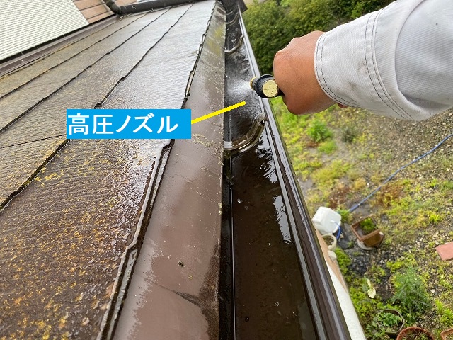 高圧ノズルで雨樋の泥を洗い流す