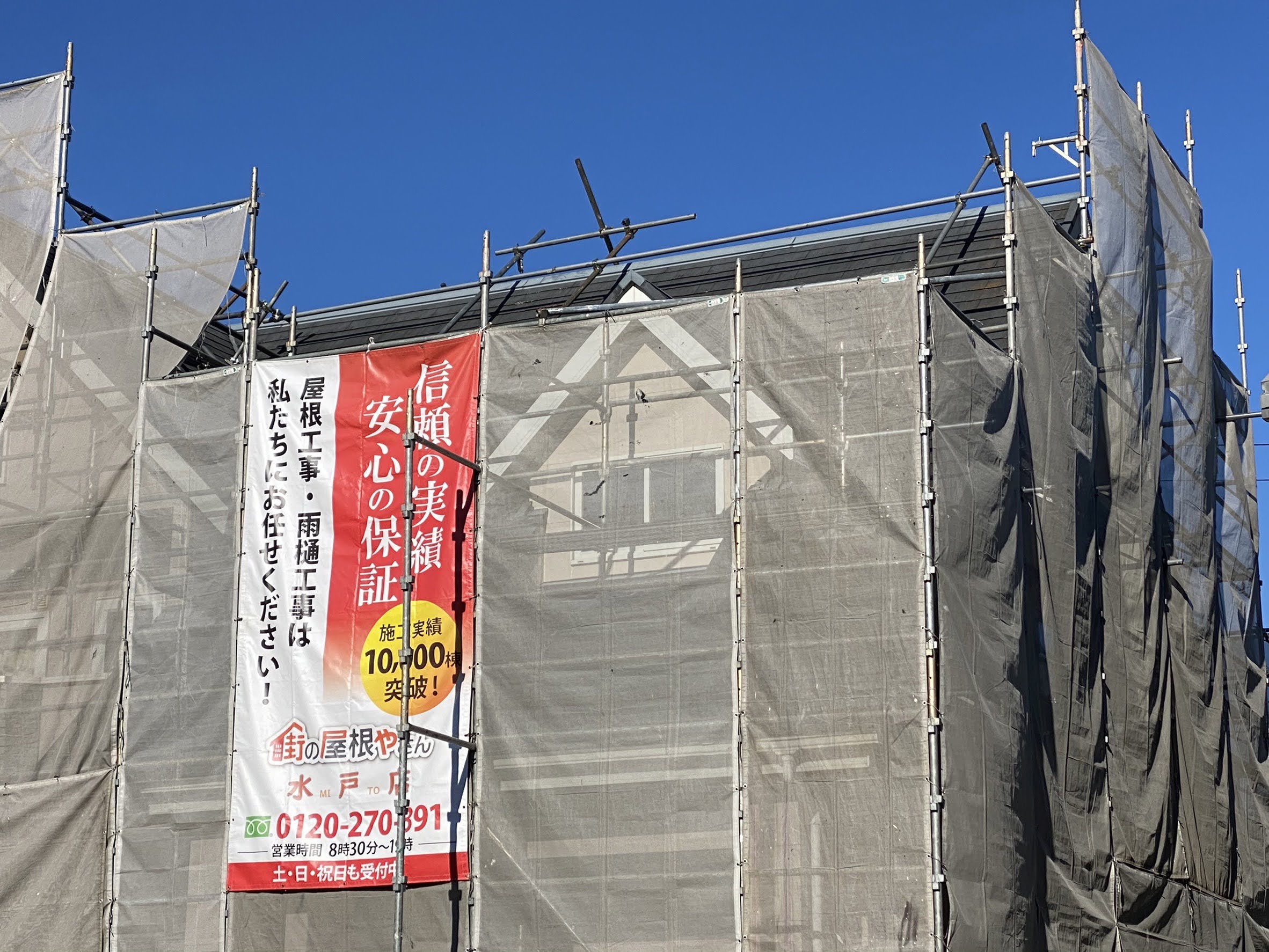 街の屋根やさん水戸店のタペストリーが掛かった足場