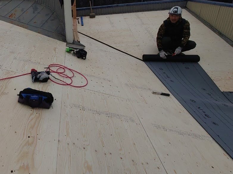 屋根カバールーフィングを施工する職人