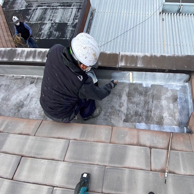 プライマーをシートに塗布する職人