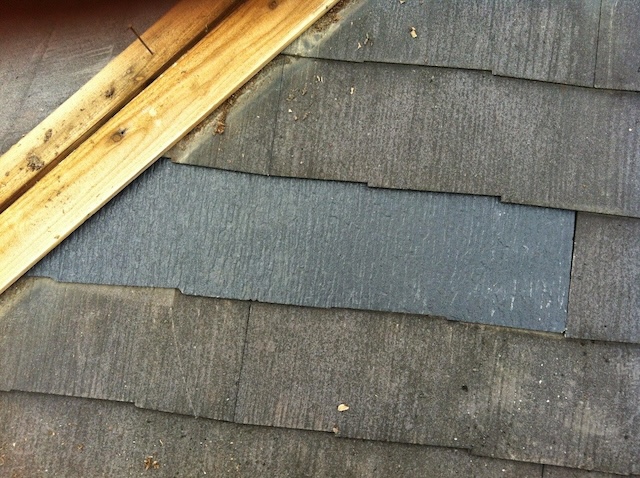 新しいカラーベスト屋根材を隙間に差し込む補修作業