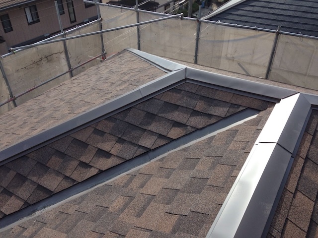 新しく交換された棟板金と、立体感のあるアスファルトシングルの重なり