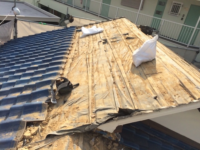 宇治市にて瓦と葺き土を撤去し、土嚢袋へ回収。屋根の軽量化を進める作業。