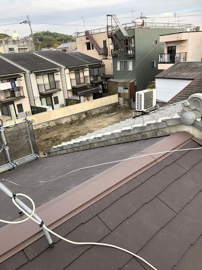 スレート屋根葺き替え工事の現場全景。足場と周辺の住宅街の様子。