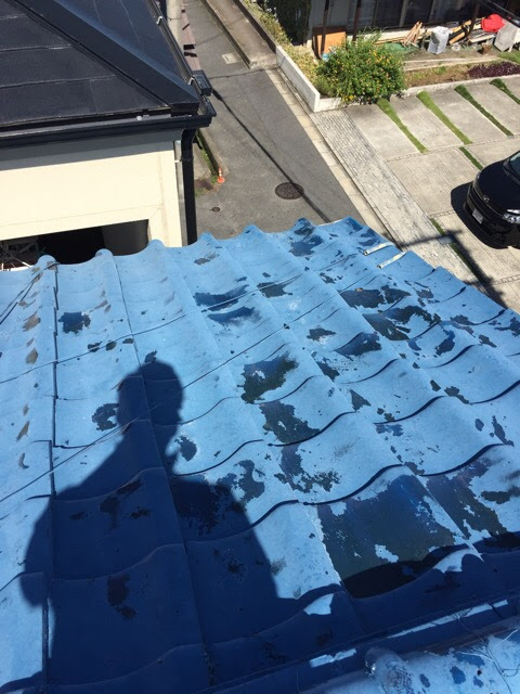 城陽市での屋根調査風景。劣化した瓦の塗装剥離の確認
